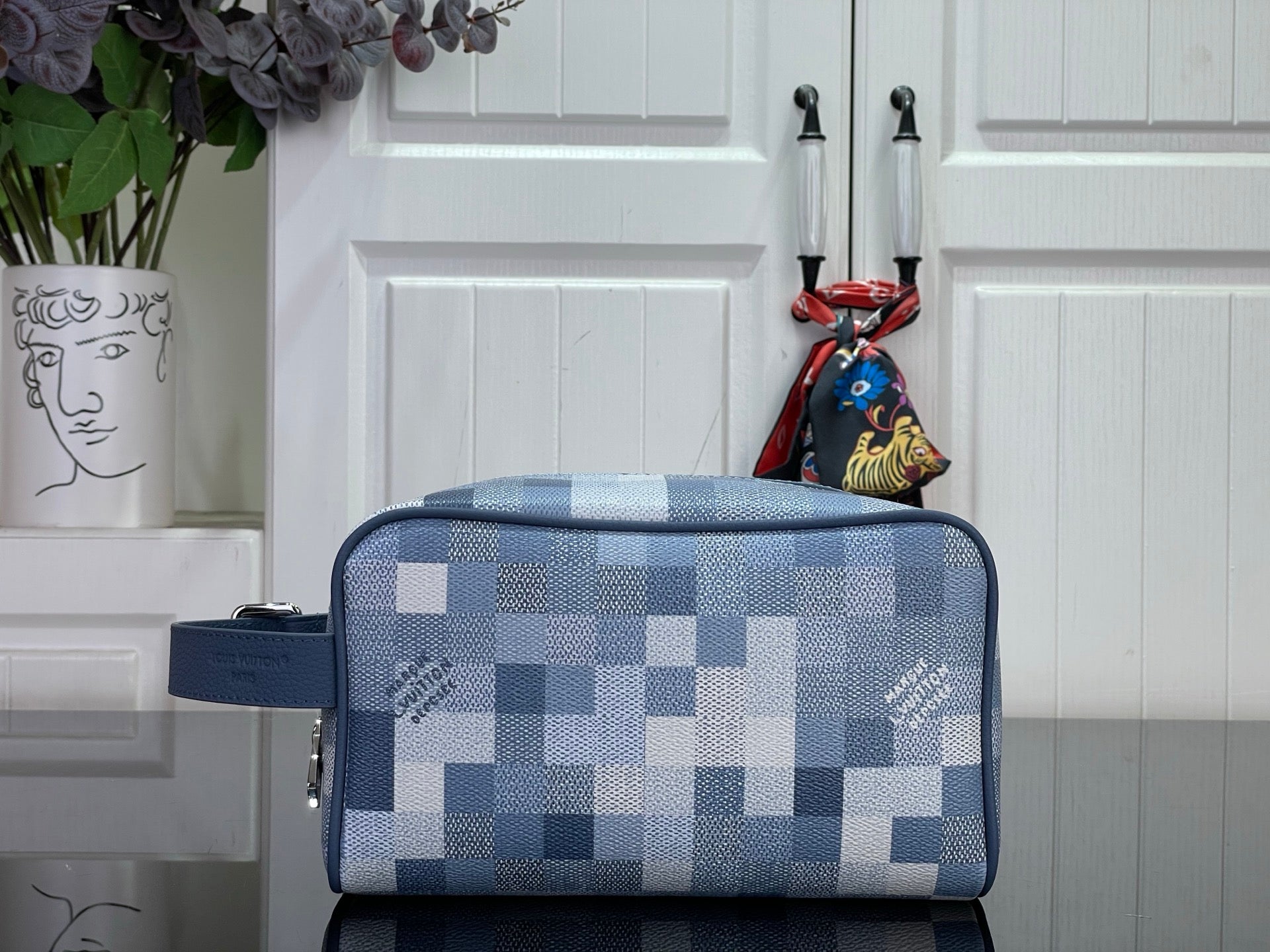 Blue check toiletry bag with top zipper and short handle