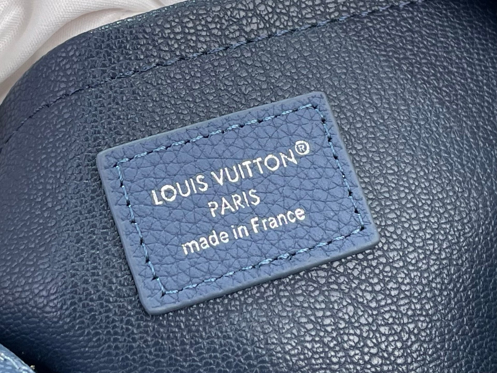 Blue pebbled leather label with Louis Vuitton Paris and made in France