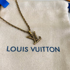 Gold-tone Louis Vuitton necklace pendant on beige dust bag