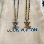 Louis Vuitton necklaces, silver and gold pendants, on beige dust bag