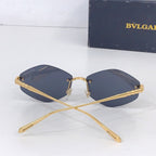 Gold round sunglasses with dark blue lenses, crossed temples, front view