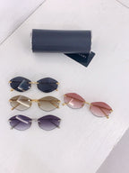 Assorted tinted sunglasses with gold frames and dark, purple, and pink lenses