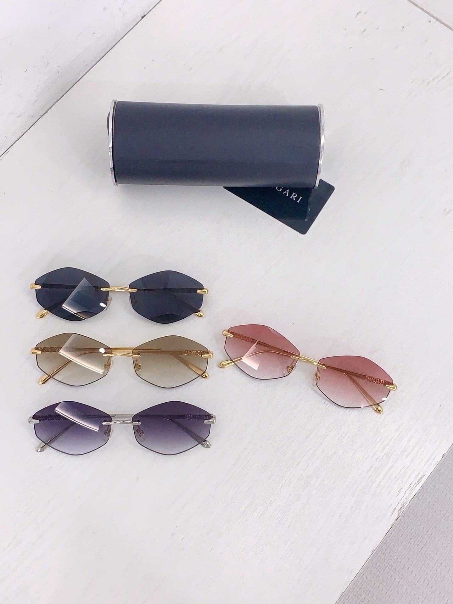 Assorted tinted sunglasses with gold frames and dark, purple, and pink lenses