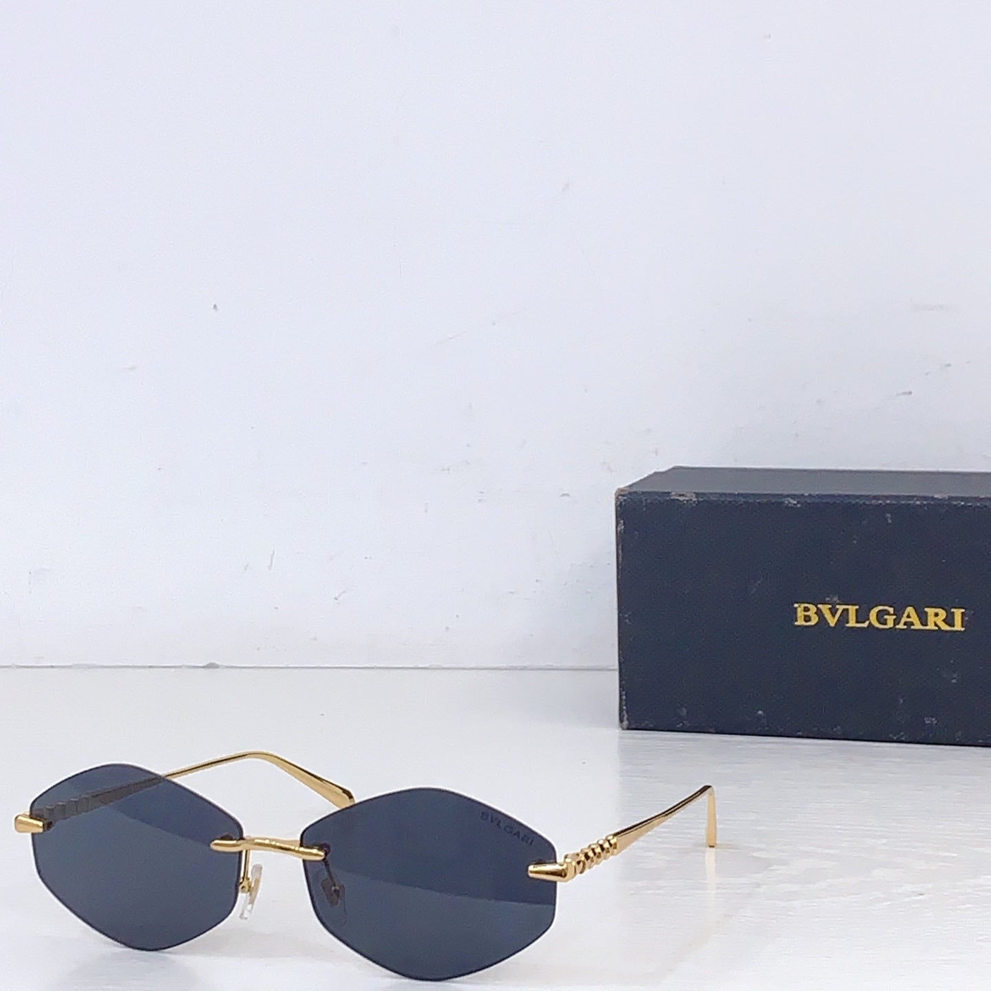 Gold-rim round sunglasses with dark blue lenses and metal side arms
