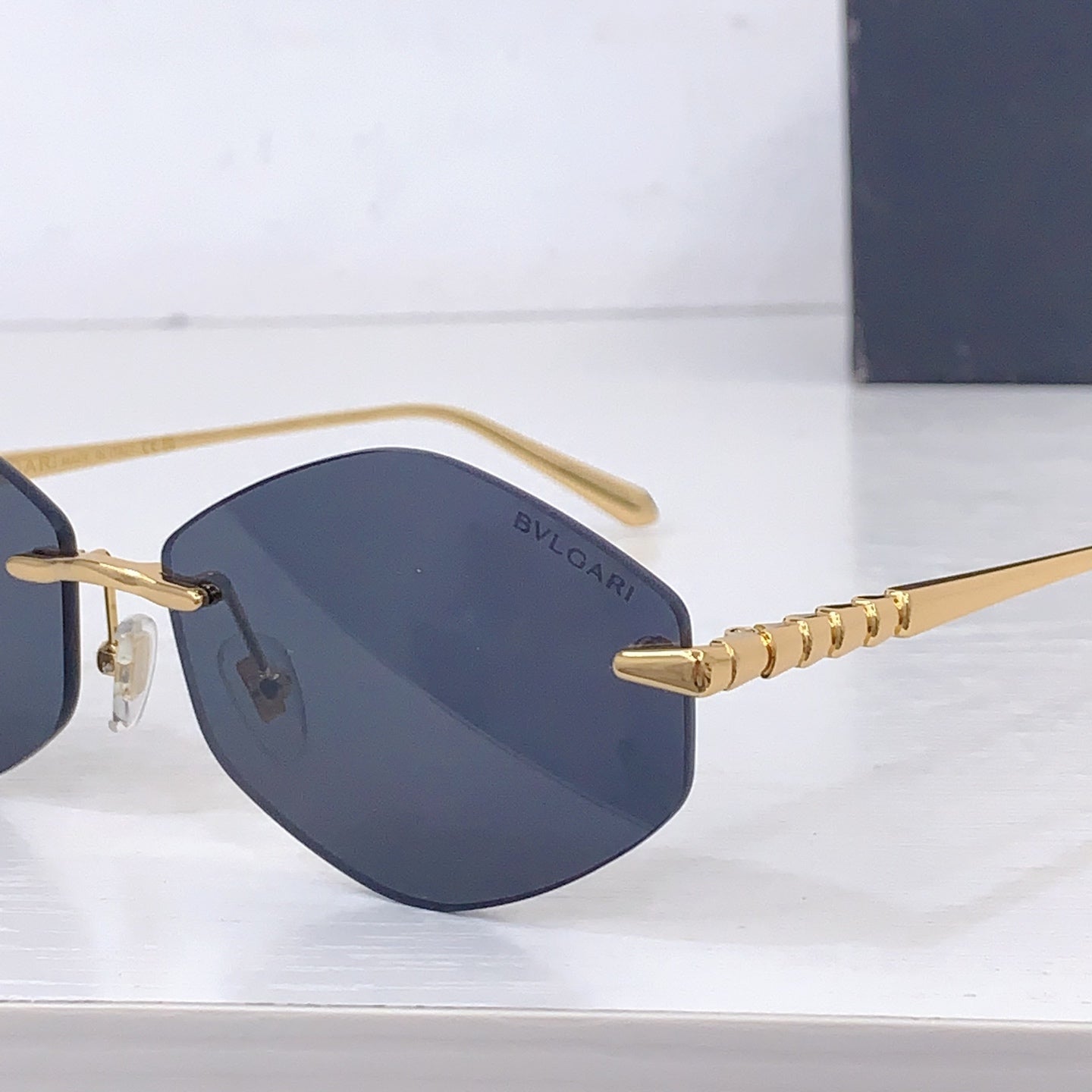 Gold sunglasses side view with blue tinted lens and beaded temple detail