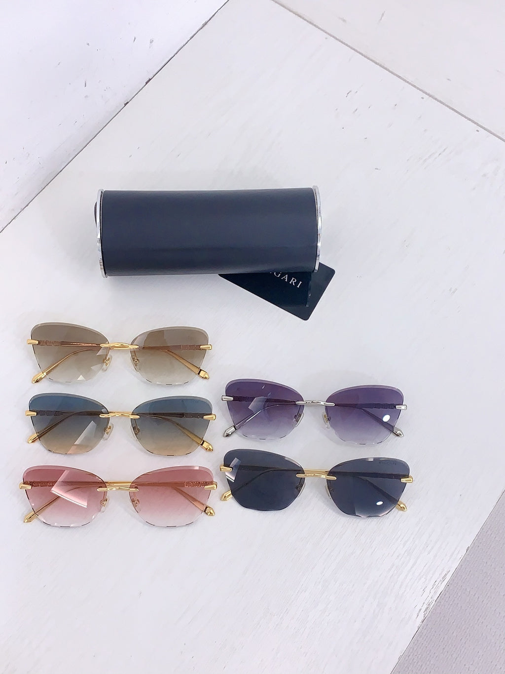 Bvlgari sunglasses assortment with gold frames and tinted lenses in pink, blue and purple.