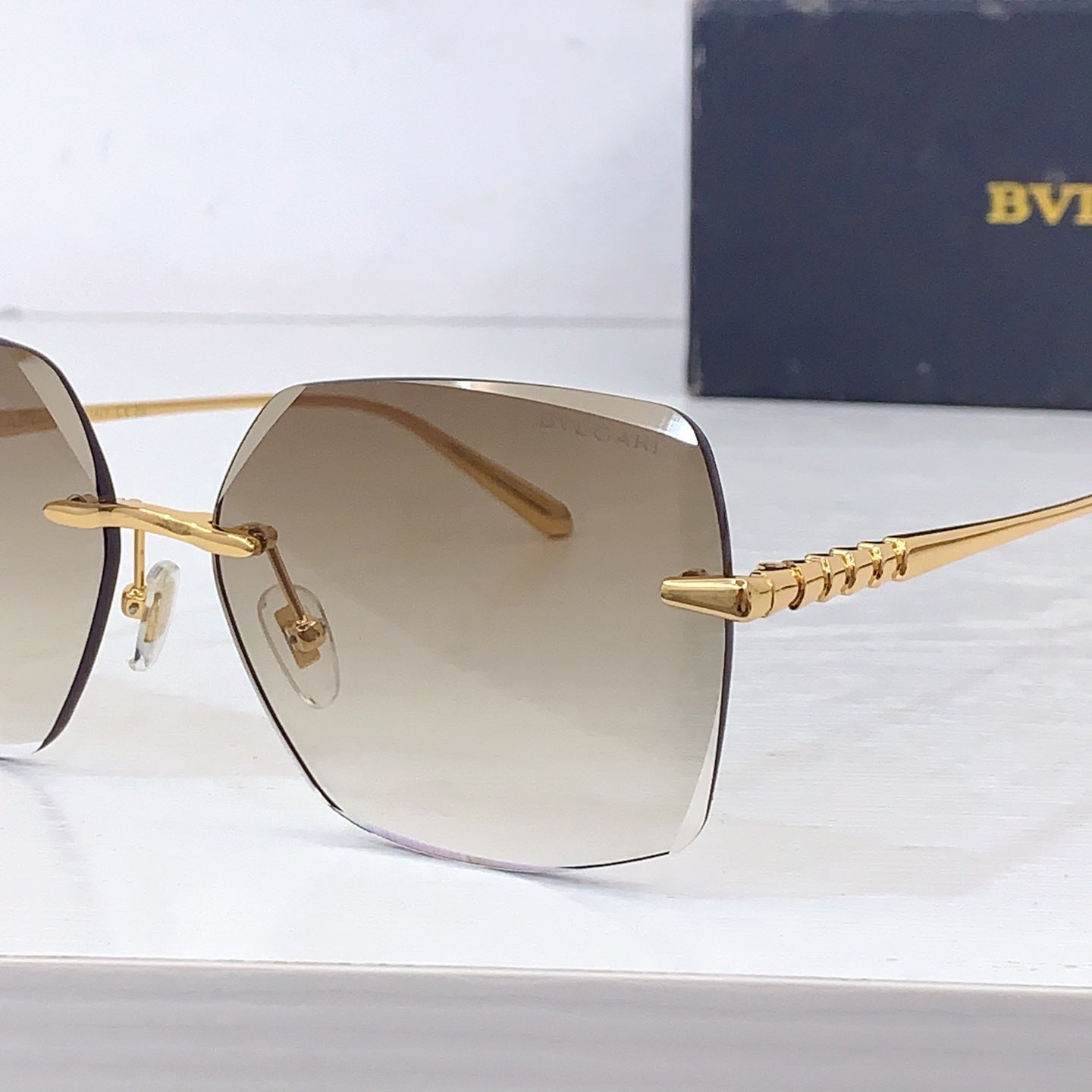 Bvlgari sunglasses close-up of gold temple chain and beige gradient lens