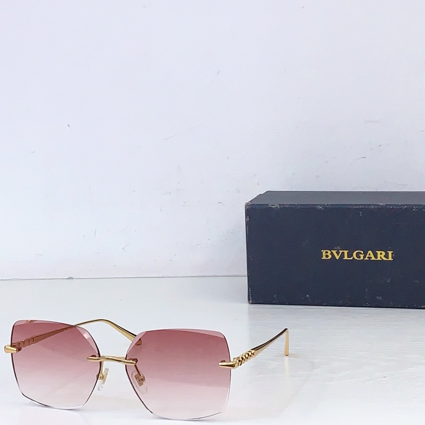 Bvlgari sunglasses with gold frame and pink gradient lenses, rectangular shield shape