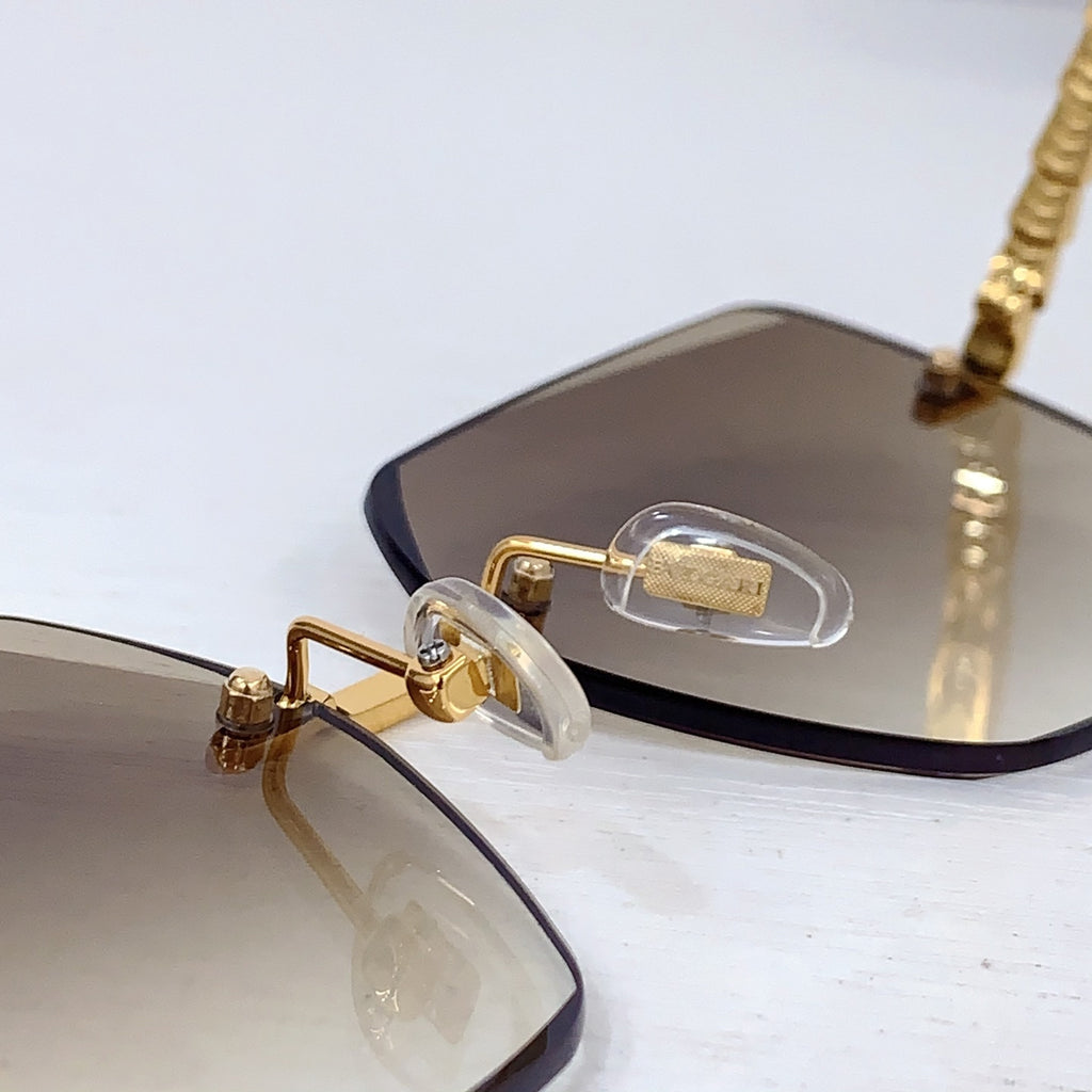 Bvlgari sunglasses close-up of gold nose bridge and beige gradient lenses