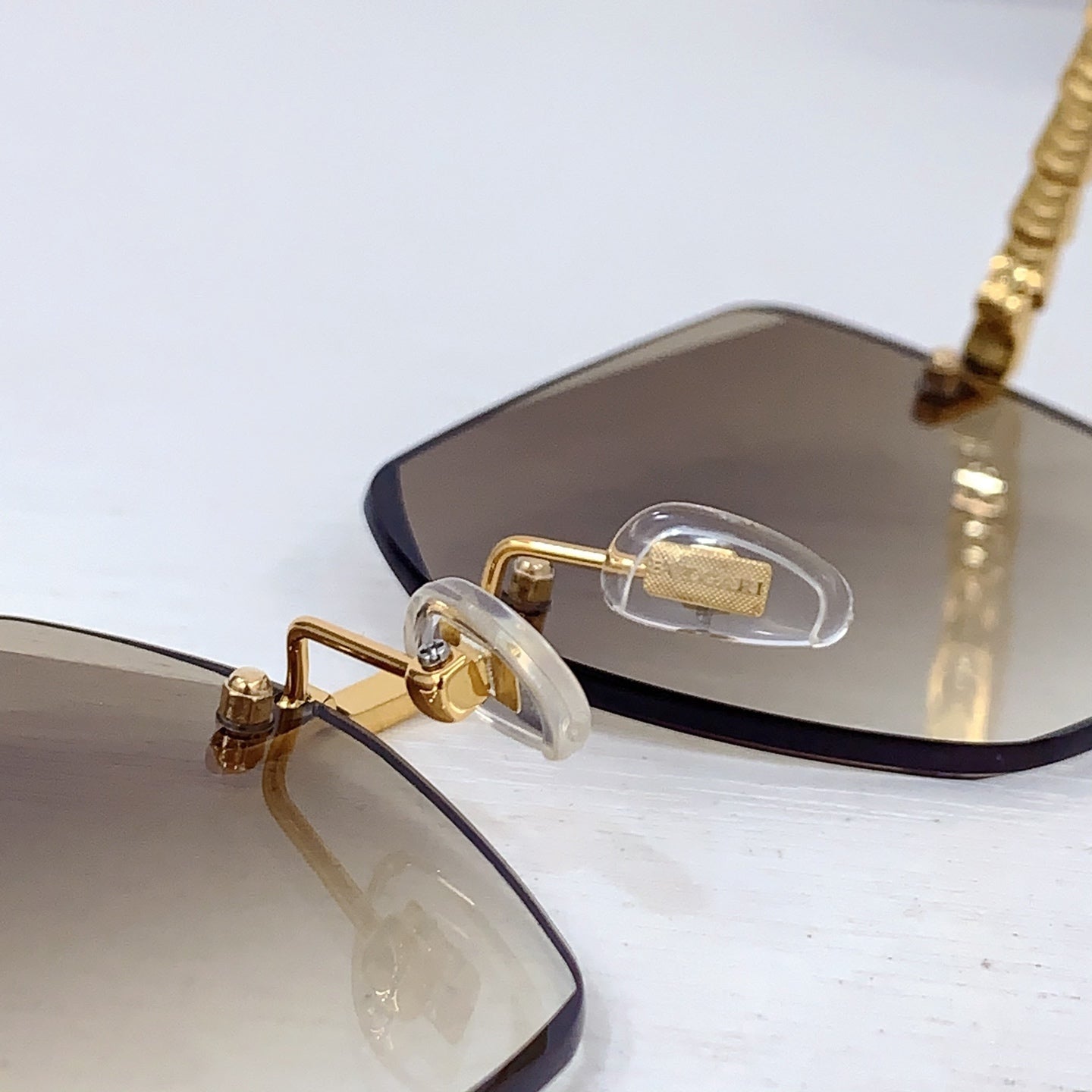 Bvlgari sunglasses close-up of gold nose bridge and beige gradient lenses