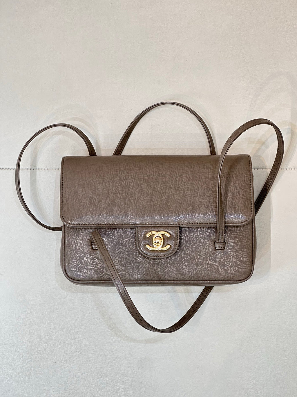 Taupe Chanel small shoulder bag with flap front, gold CC emblem, and two straps