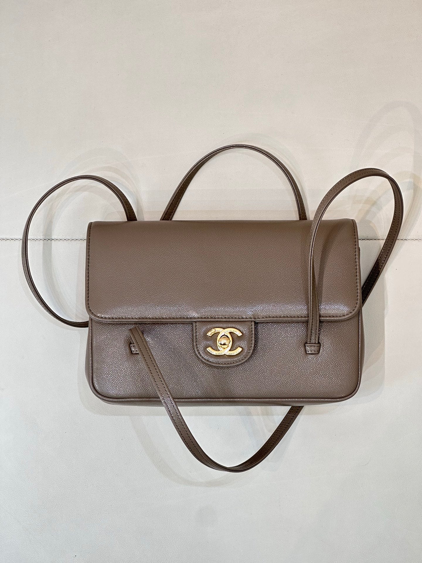 Taupe Chanel small shoulder bag with flap front, gold CC emblem, and two straps