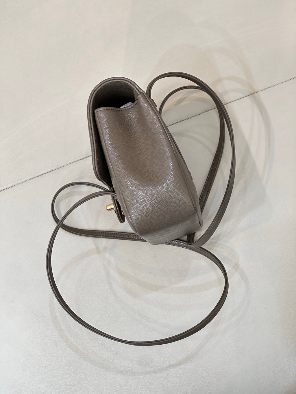Taupe Chanel small leather bag with side pocket, gold hardware, and long strap