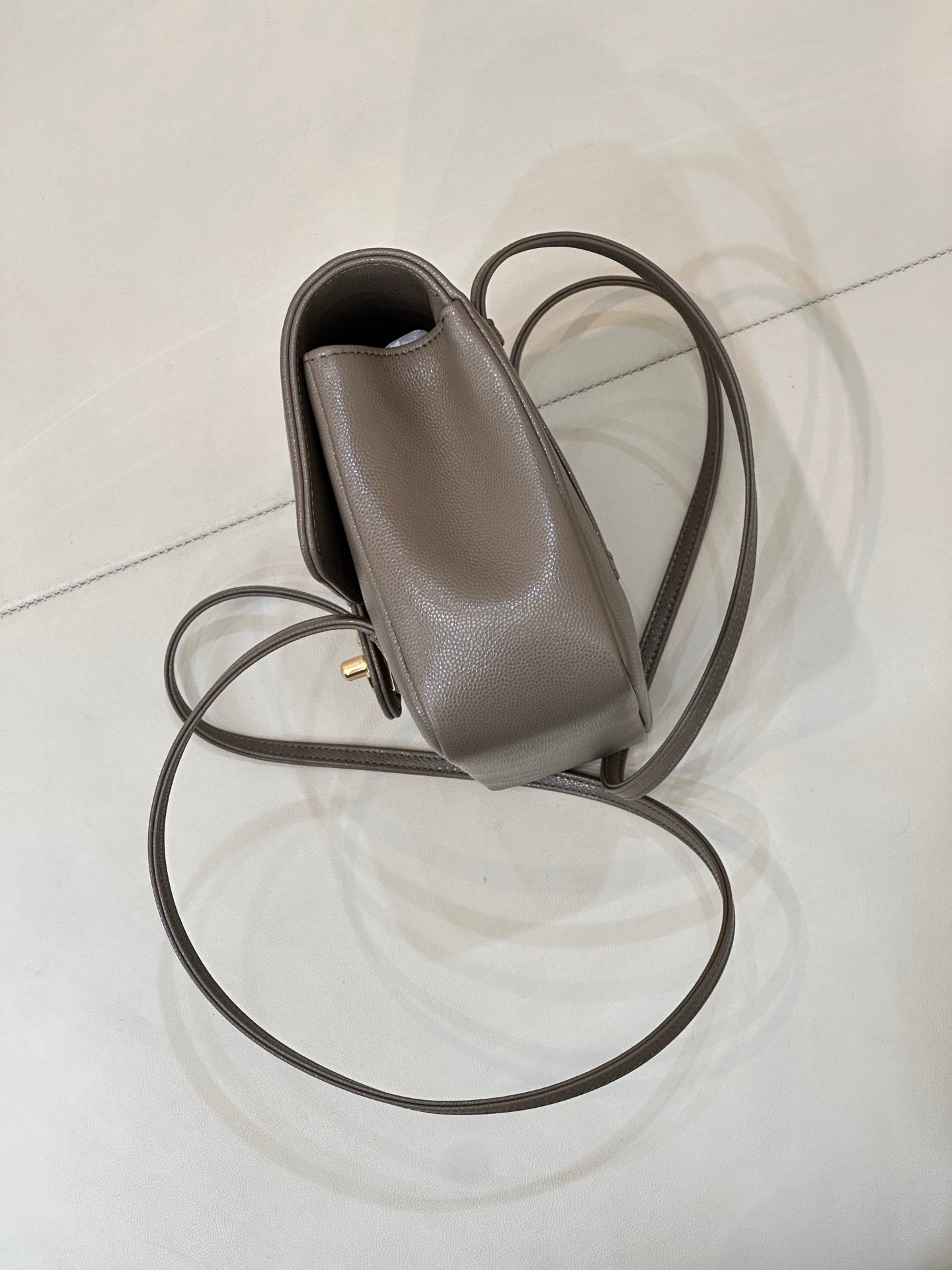 Taupe Chanel small leather bag with side pocket, gold hardware, and long strap