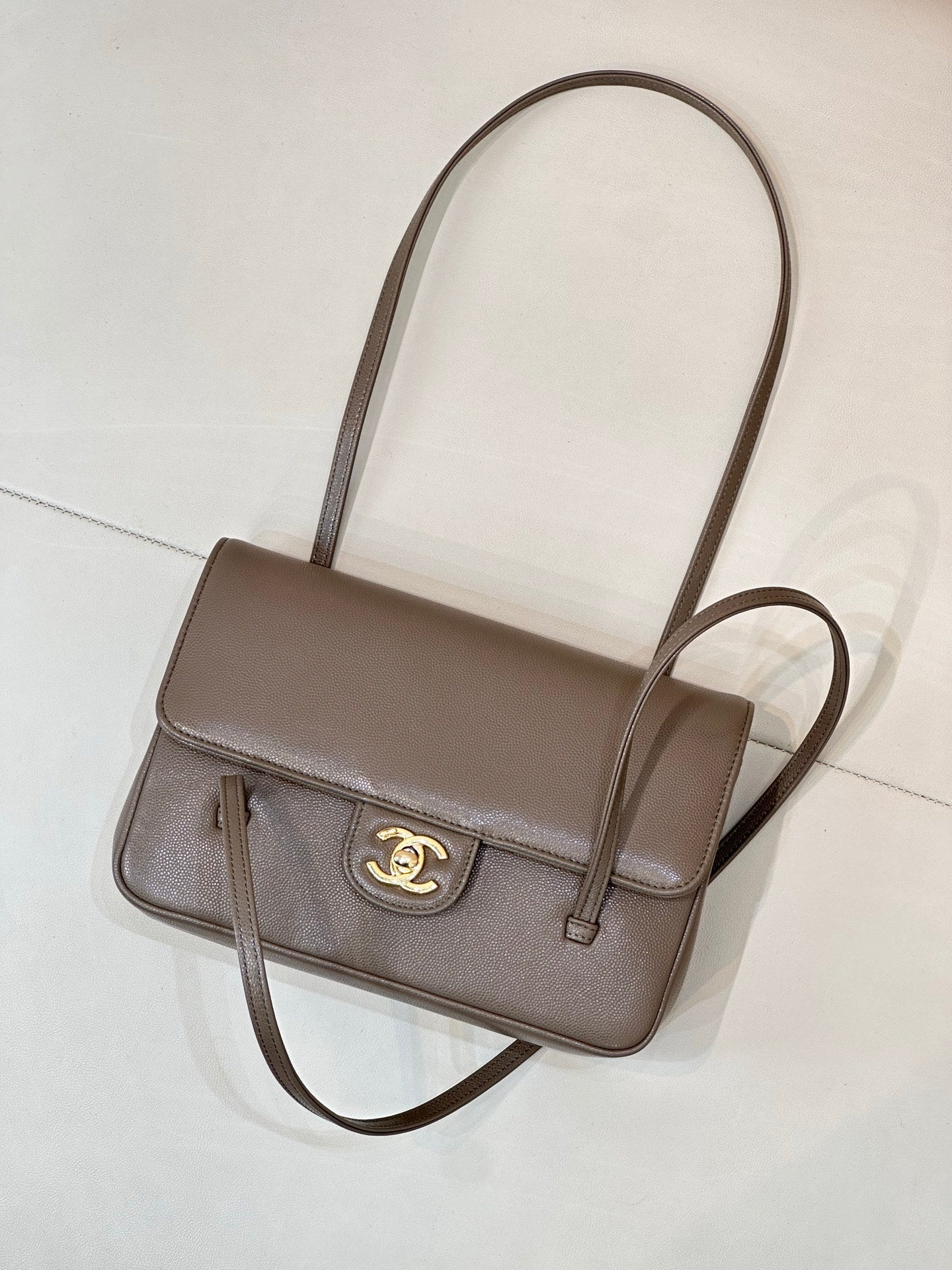 Taupe Chanel shoulder bag with cross-body strap, front flap, and gold CC logo