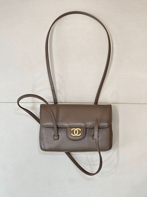 Chanel bag in taupe leather with gold CC logo, front flap, and long crossbody strap.