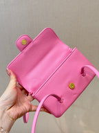 Chanel pink mini bag with flap open, interior pocket lining, and gold button details