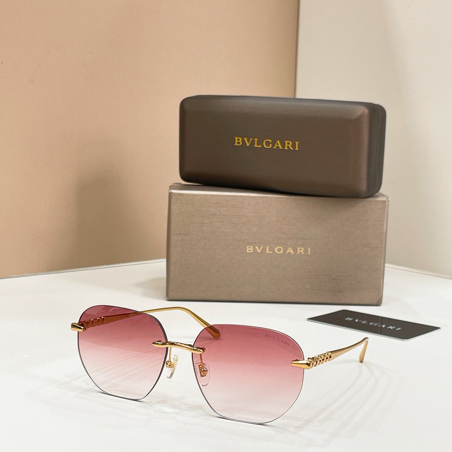 Round Bvlgari sunglasses with pink lenses and gold-tone frames