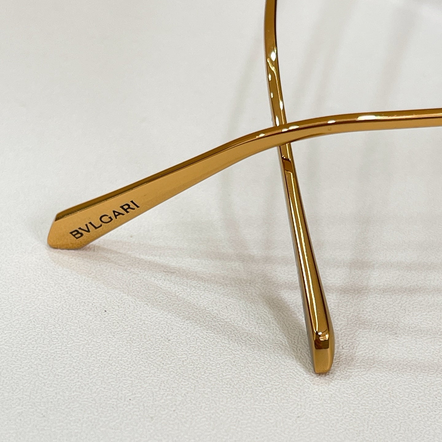 Gold Bvlgari sunglasses frame arm with logo text