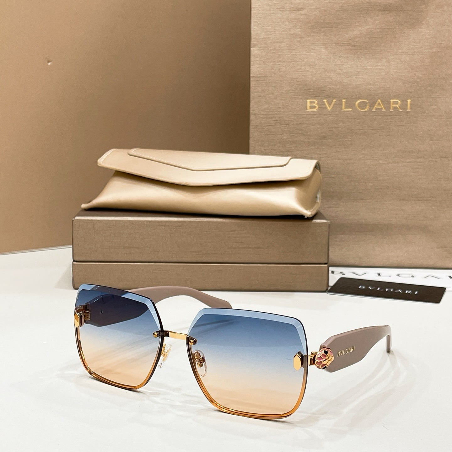 Bvlgari sunglasses with blue-to-brown tinted lenses and gold-toned frame