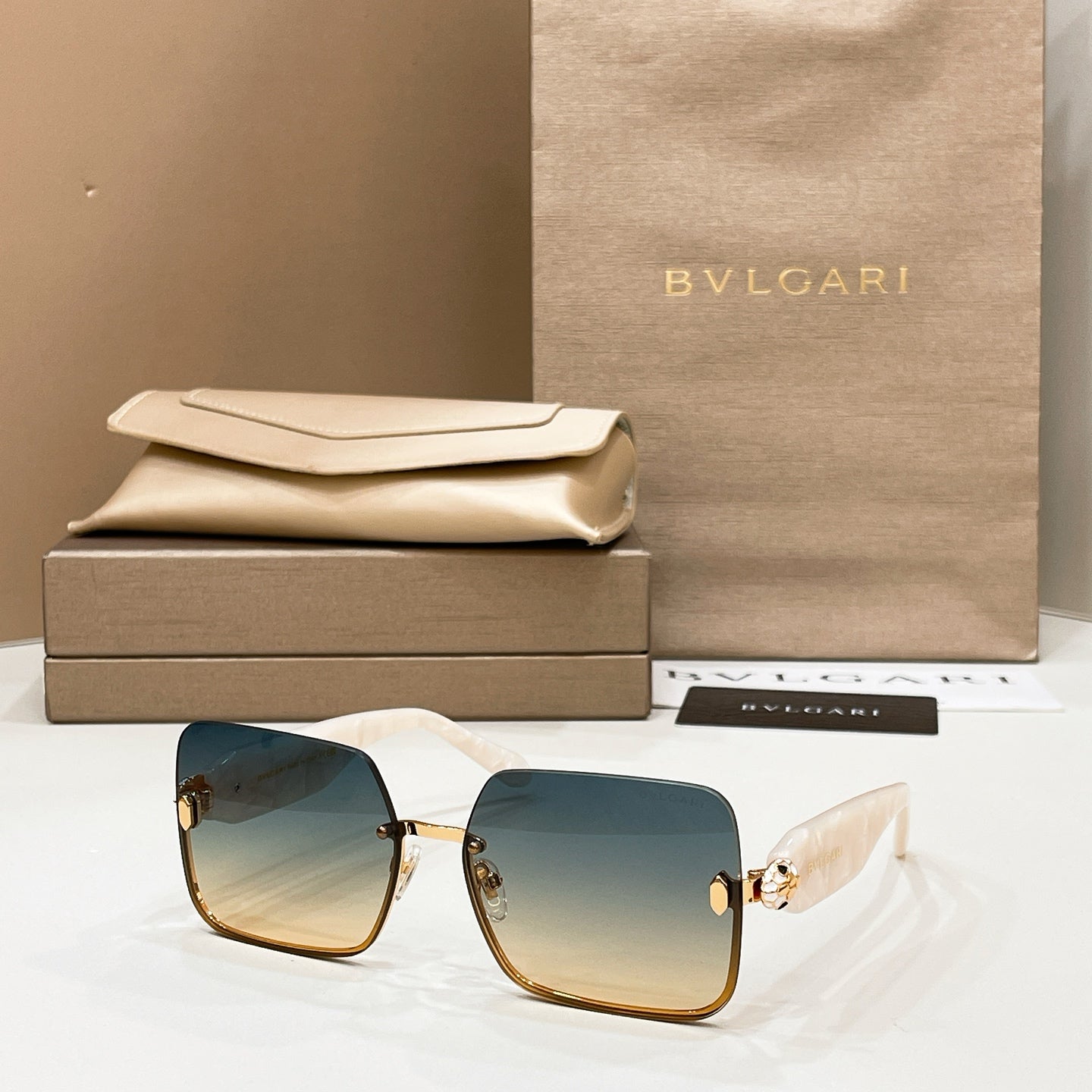 Bvlgari square sunglasses with teal-blue lenses and gold-tone metal frame