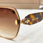 Bvlgari sunglasses close-up: tortoiseshell arms, gold lion emblem, brown lenses