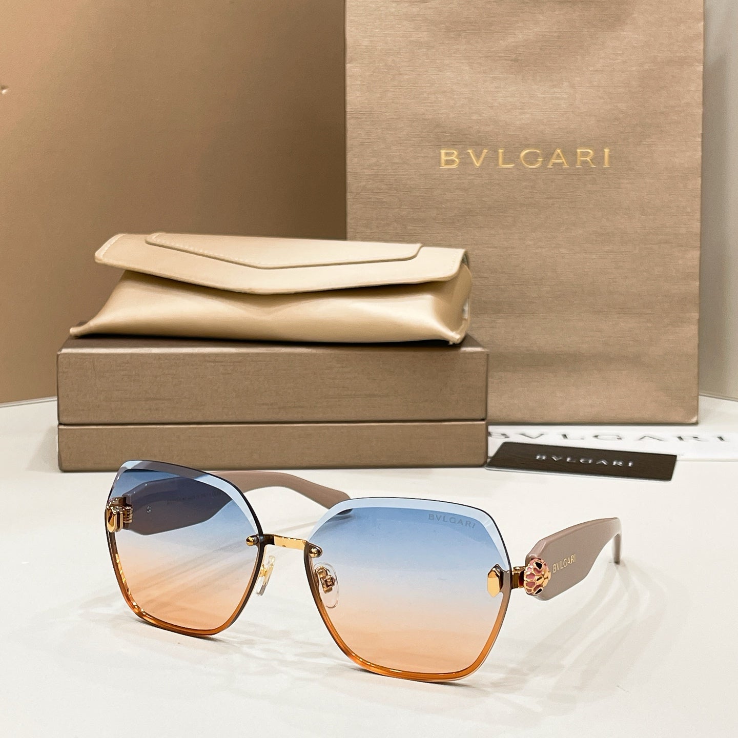 Bvlgari sunglasses with light blue gradient lenses, gold accents, and tortoiseshell rims