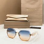 Bvlgari sunglasses with blue gradient lenses, gold accents, and light tortoiseshell frames