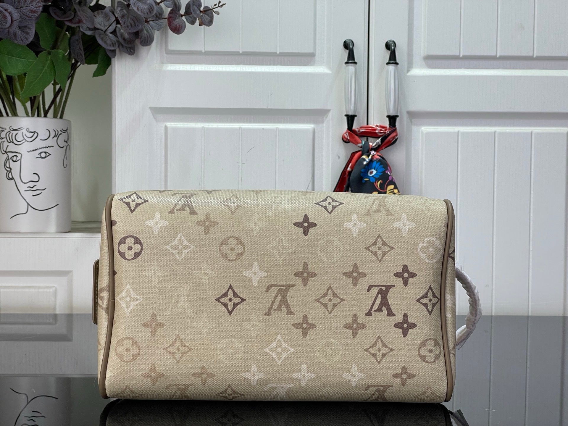 Louis Vuitton monogram canvas bag with wide top opening and tan leather side handle