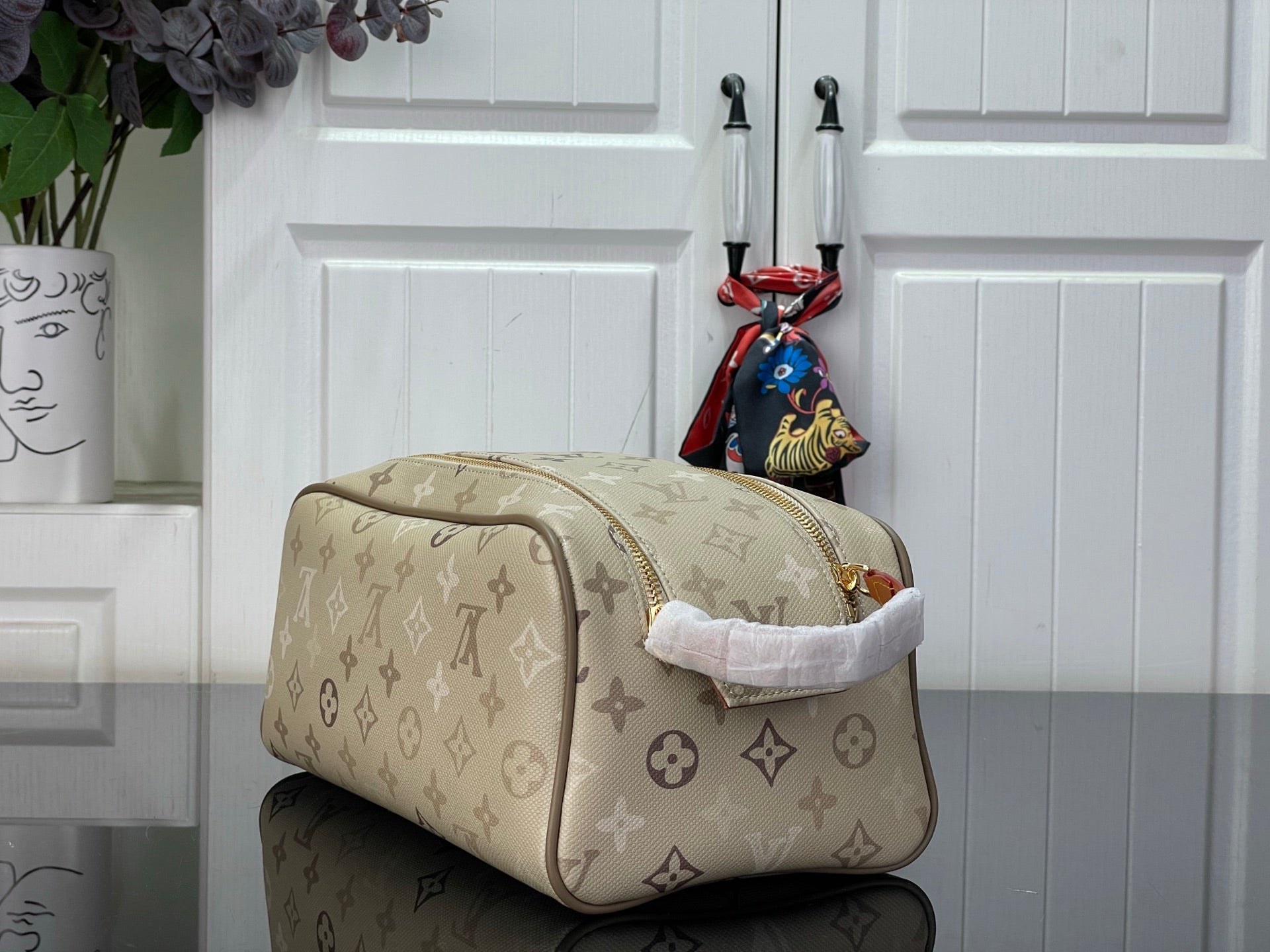 Louis Vuitton monogram canvas duffel-style bag with tan leather trim and top zip