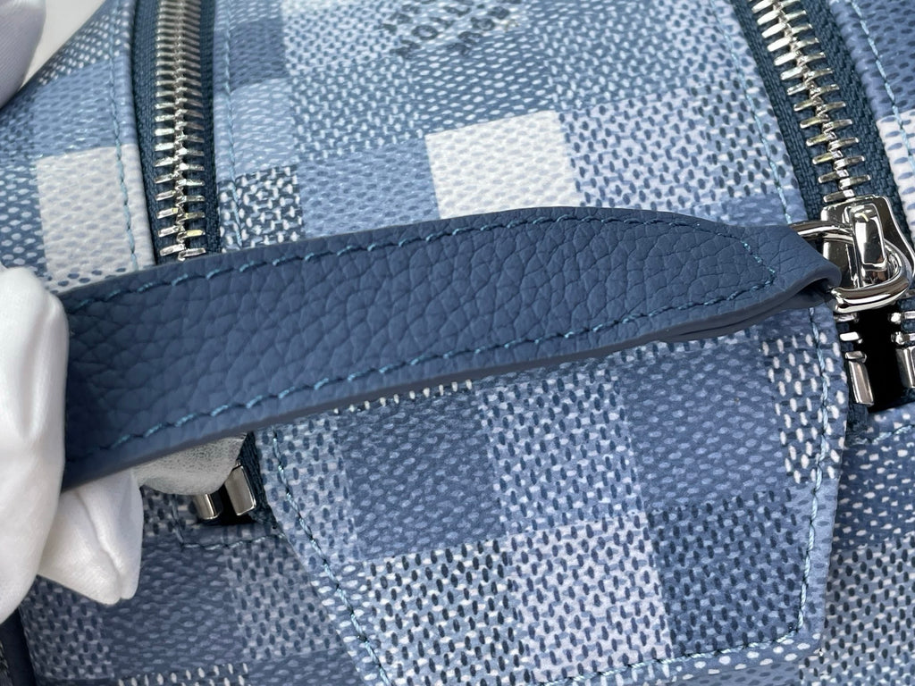 Checkered blue-and-white toiletry bag with blue leather side pocket and zipper