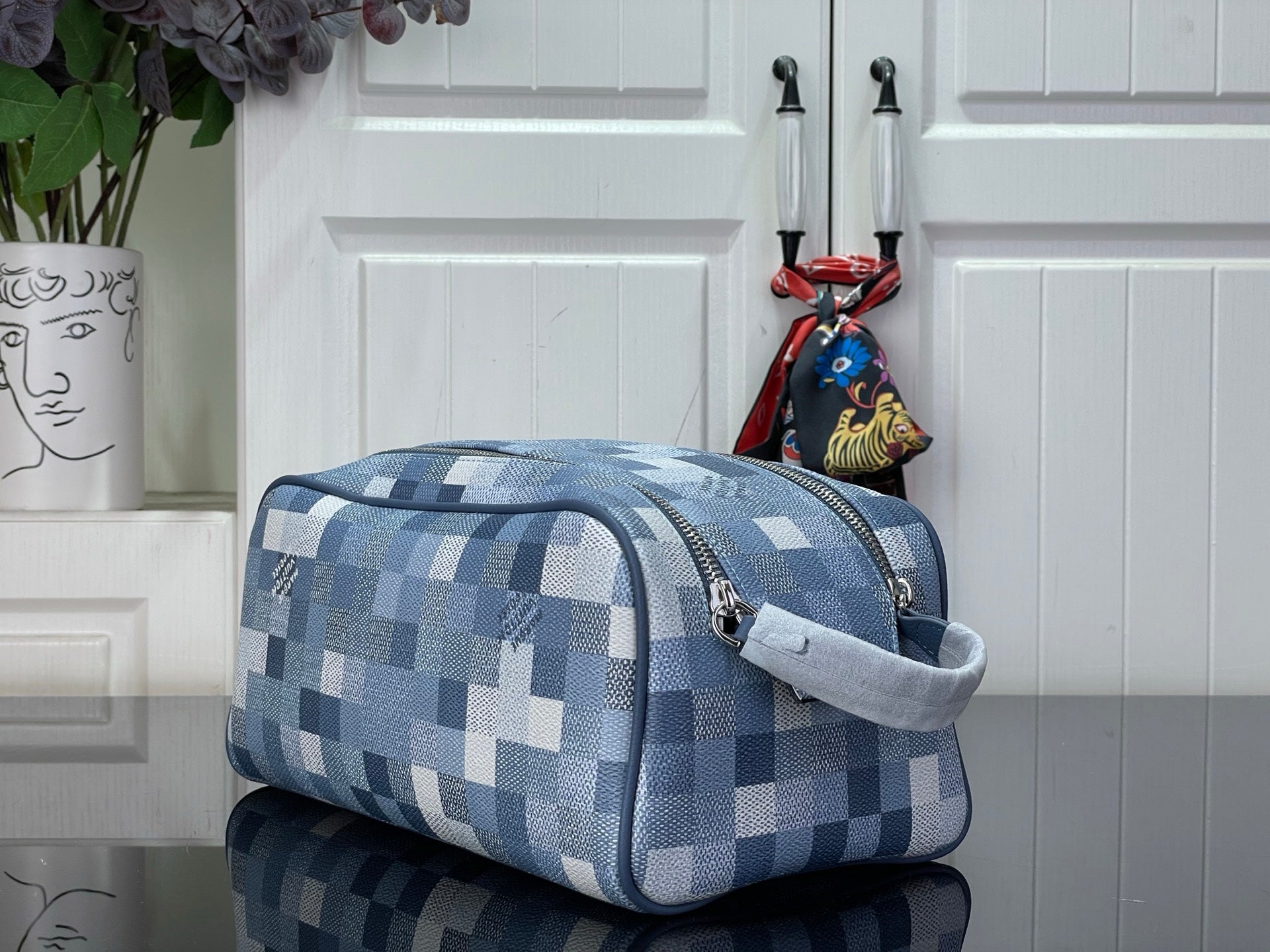 Checkered blue-and-white toiletry bag with curved handle and side zipper