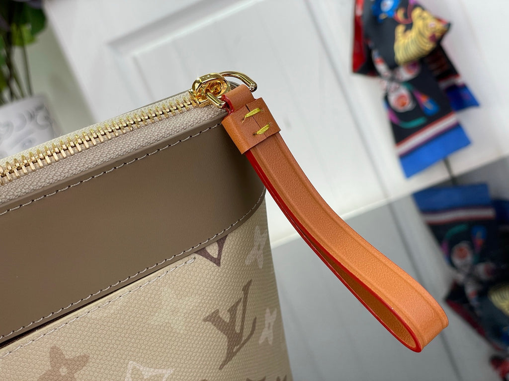 Zippered monogram bag edge with tan leather trim and orange strap