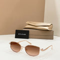 Gold-tone sunglasses with brown lenses, shown with beige case