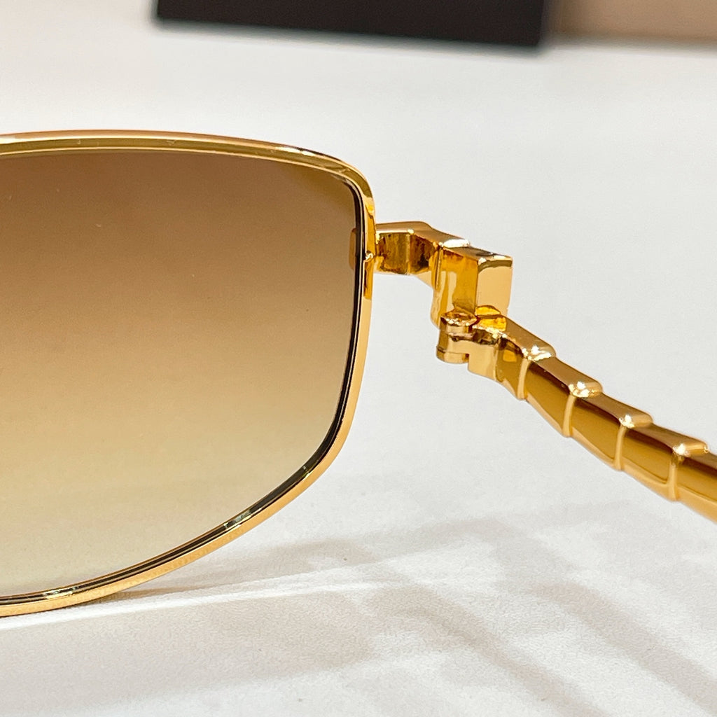 Gold-tone sunglasses close-up: lens edge with hinge detail on temple