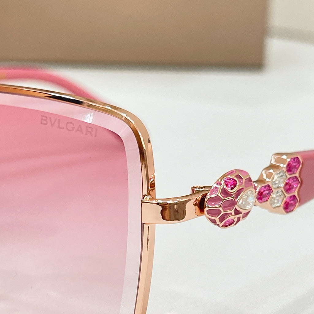 Pink tinted square sunglasses close-up with gold frame and jeweled detail