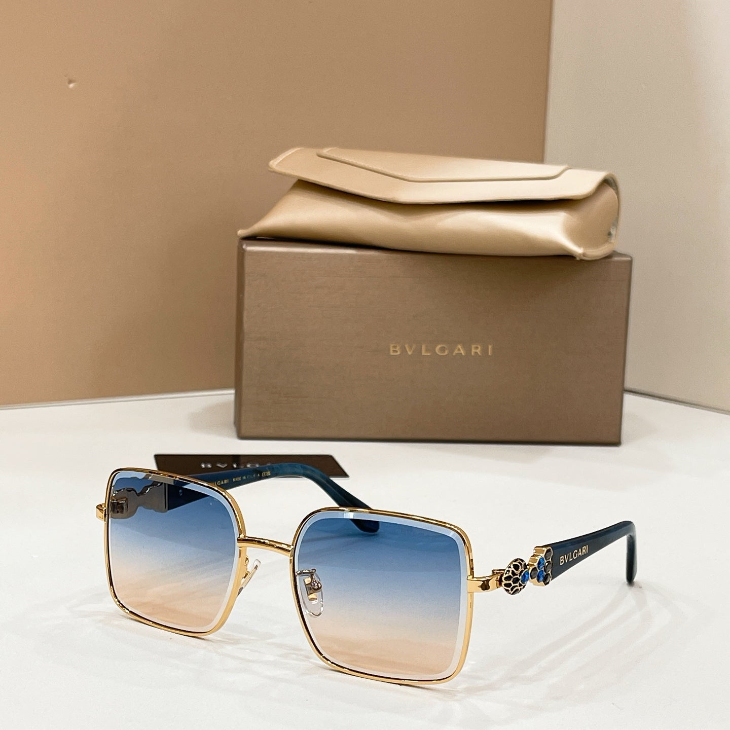 Gold-tone square sunglasses with gradient blue lenses and dark green temples