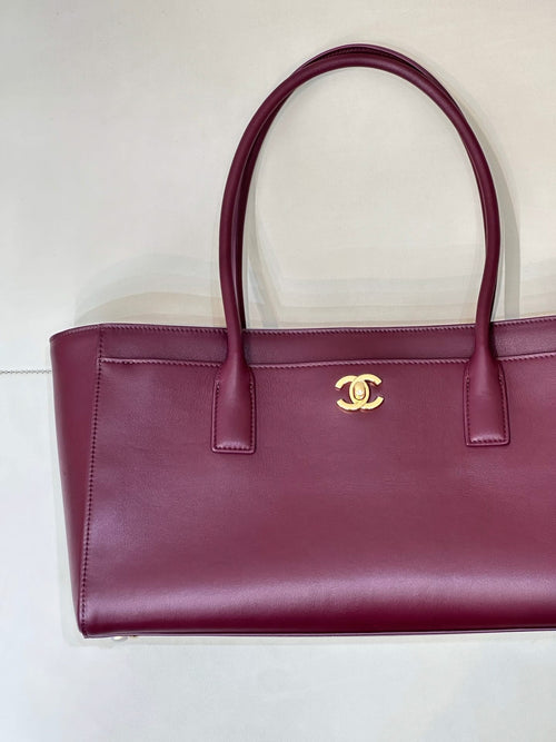 Chanel burgundy leather tote bag with front CC emblem and structured sides