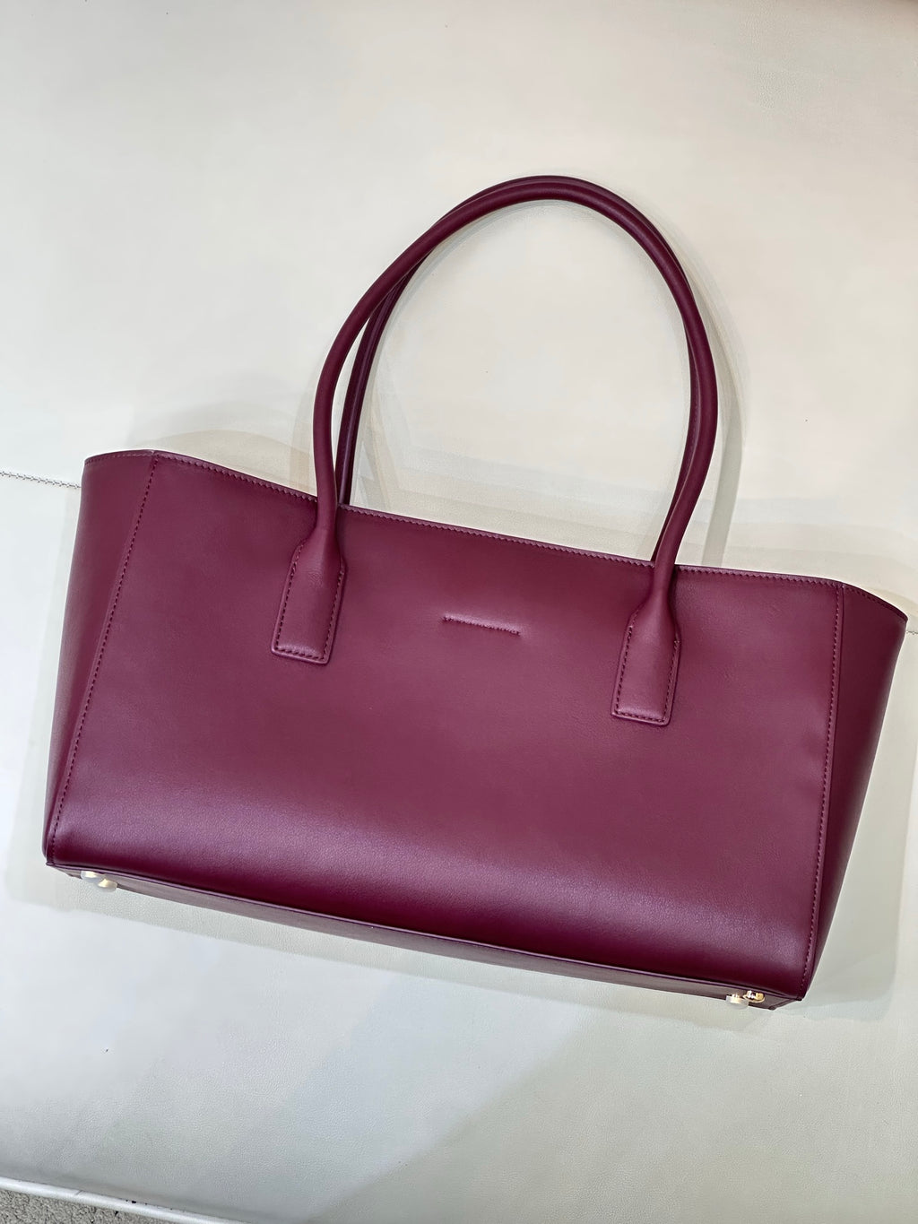 Chanel burgundy leather tote bag with flat base and metal feet