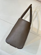 Brown leather tote bag side view with top handles and curved corner edges