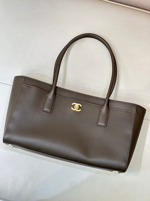 Dark taupe-brown leather tote bag with gold Chanel logo center, double top handles