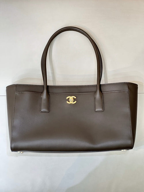 Chanel logo leather tote bag with structured sides, flat top handles, dark taupe-brown