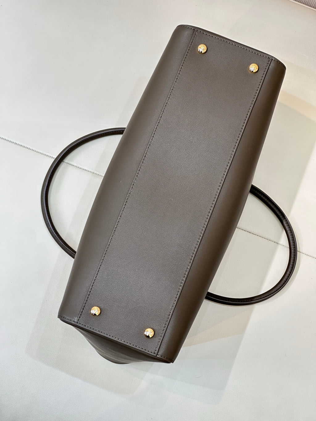 Taupe-brown leather shoulder bag with gold studs and long strap, front panel detail