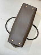 Taupe-brown leather shoulder bag with gold studs and long strap, front panel detail