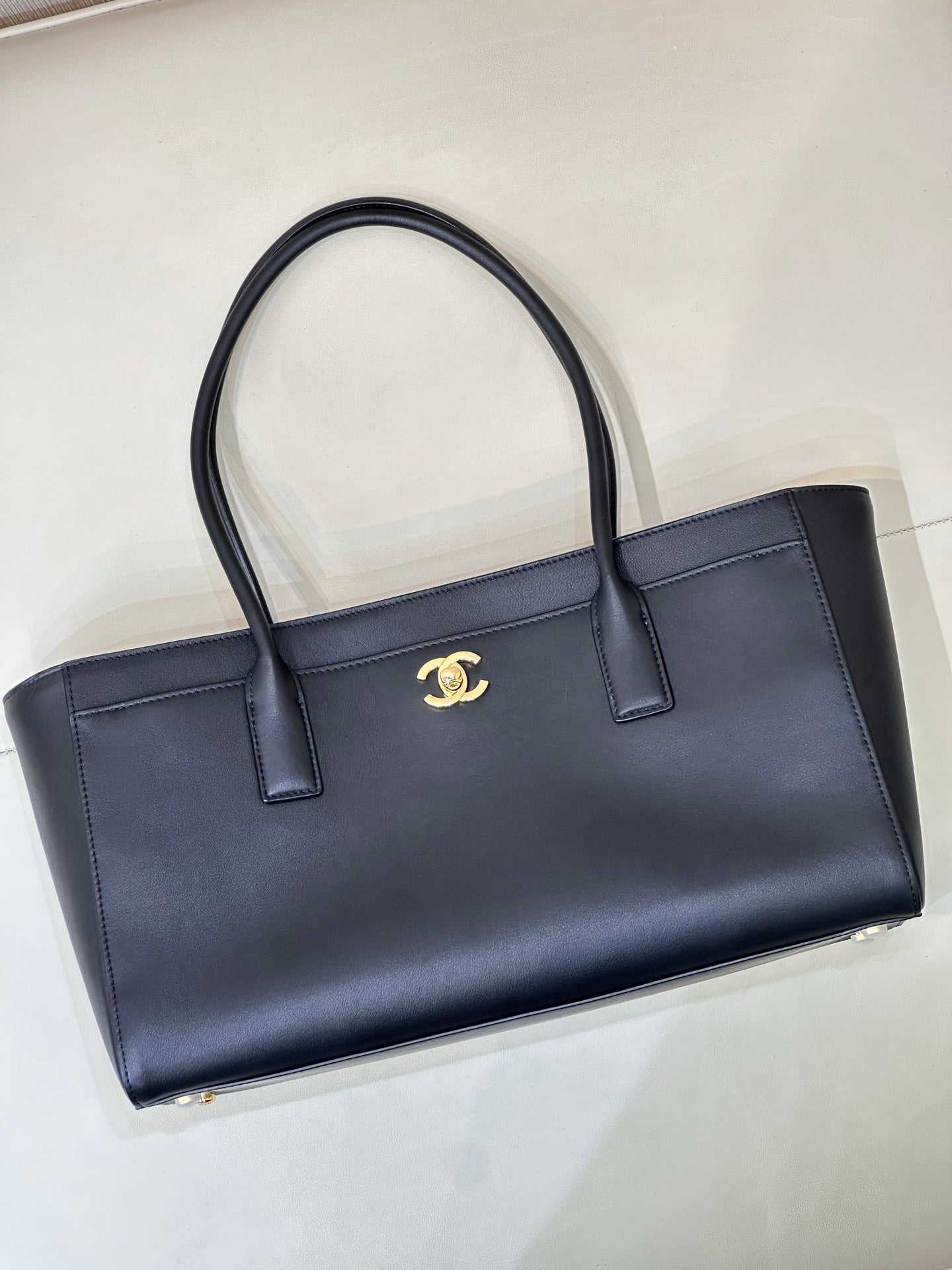 Navy Chanel leather tote bag with gold CC logo, structured front and top handles