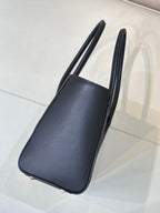 Navy leather tote bag side profile with flat bottom and tall top handles