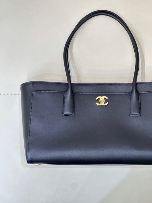 Navy leather tote bag with gold CC logo, structured front and two top handles