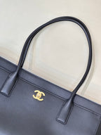 Navy leather tote bag front with gold CC logo and two short handle tabs