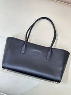 Navy leather tote bag front view with gold base feet and two top handles