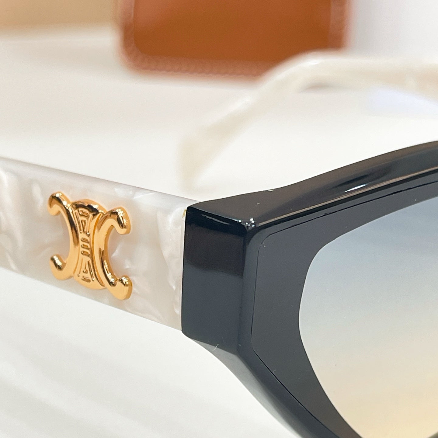 Celine logo detail on black sunglasses temple with gold emblem and tinted lens edge